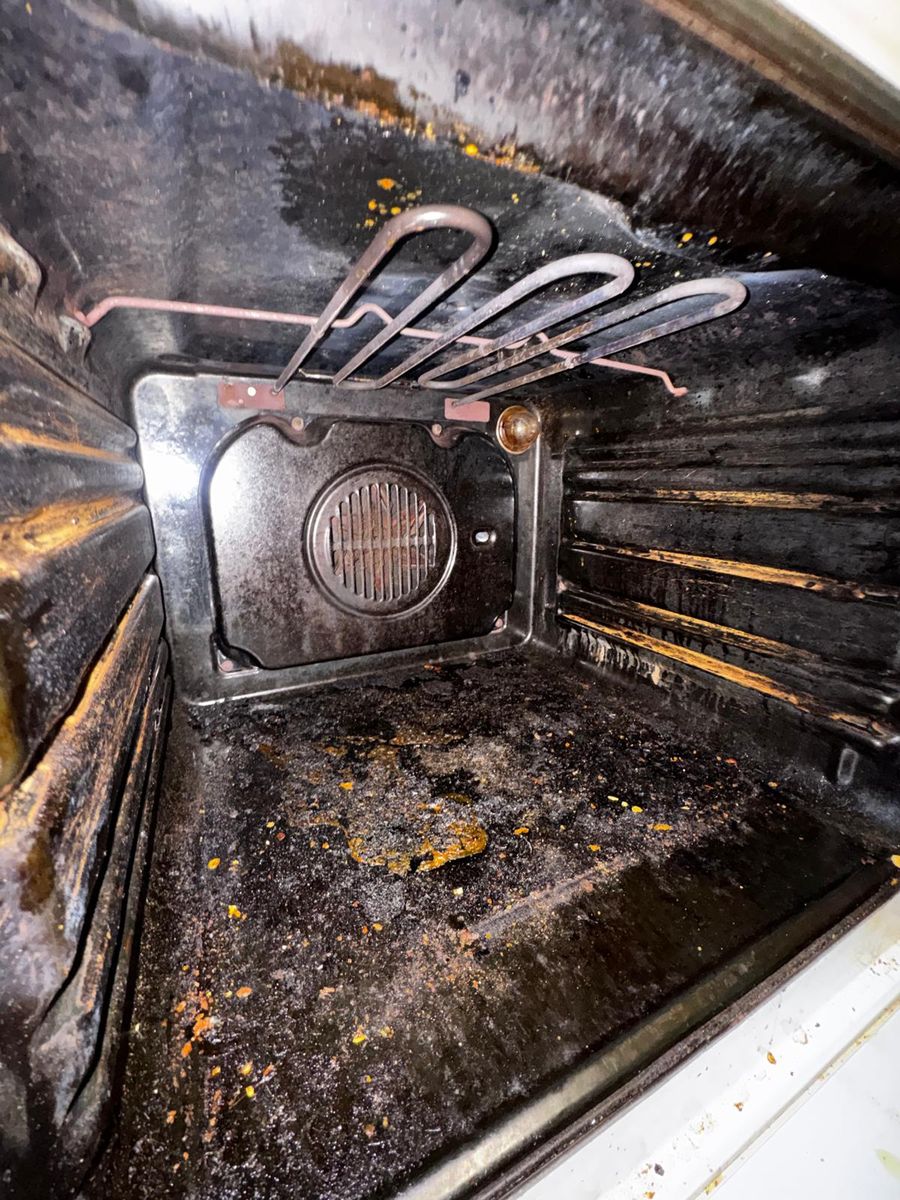 The same oven before cleaning: burnt-on grease inside